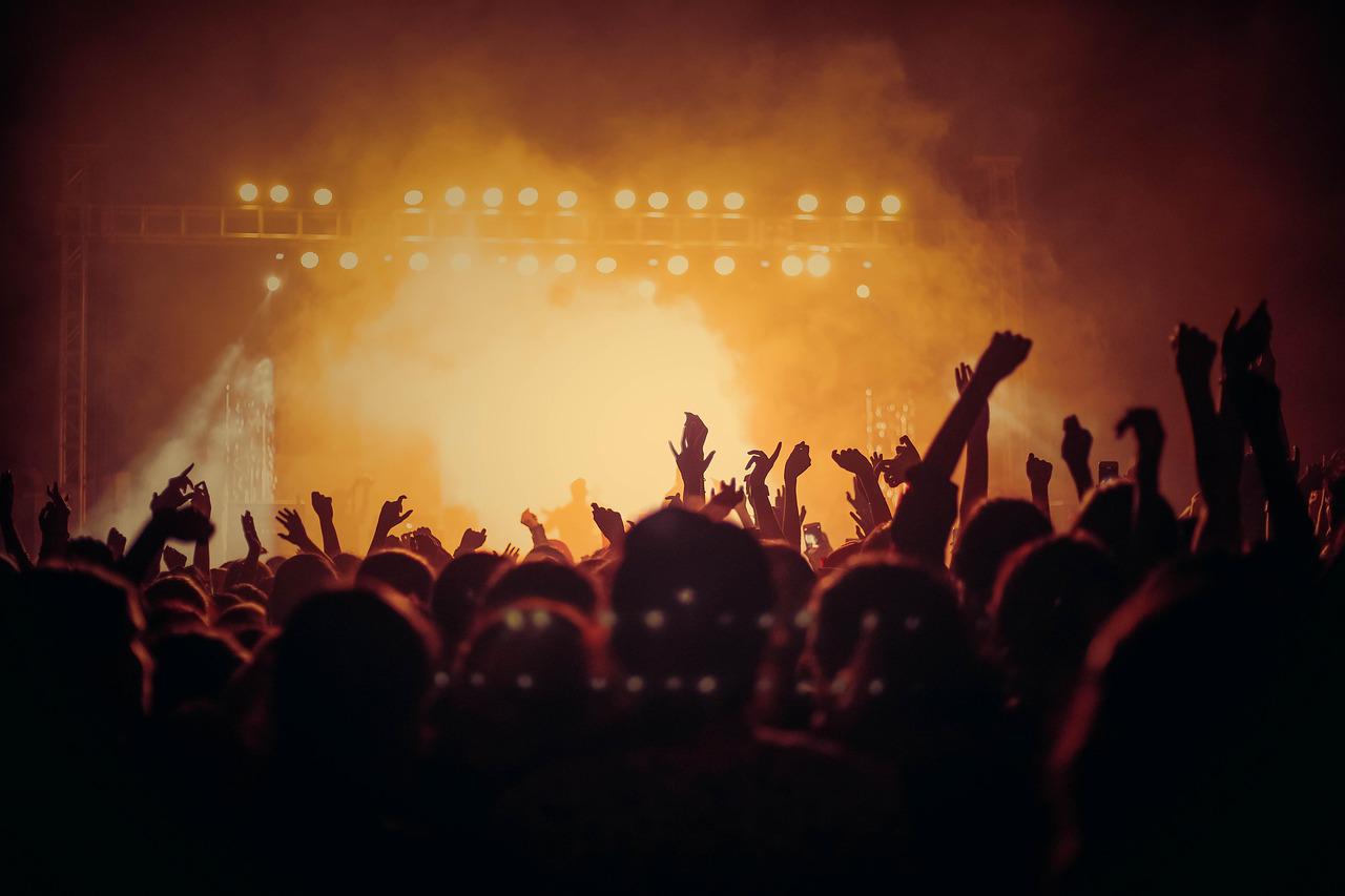 Dense concert crowd under stage lights